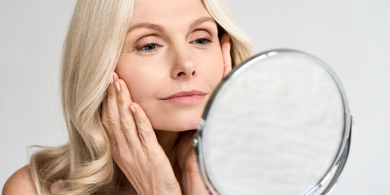Lady looking in mirror after botox treatment